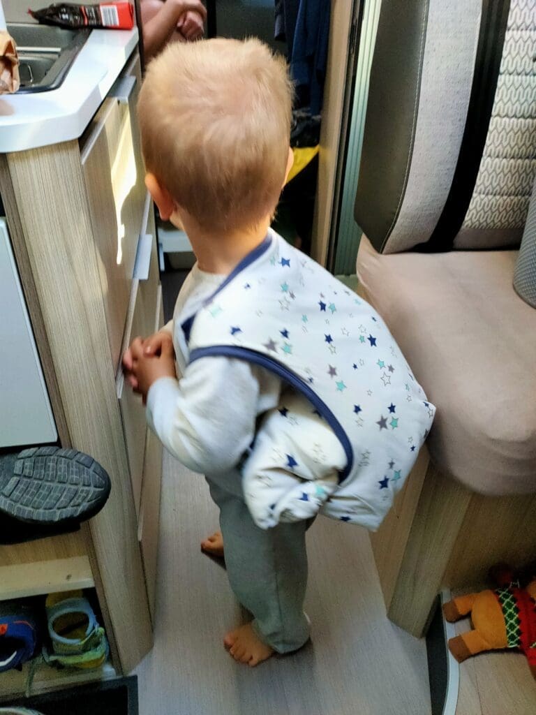 Tom et son sac à dos de doudous dans le van aménagé — vie en van en famille SED Aventures