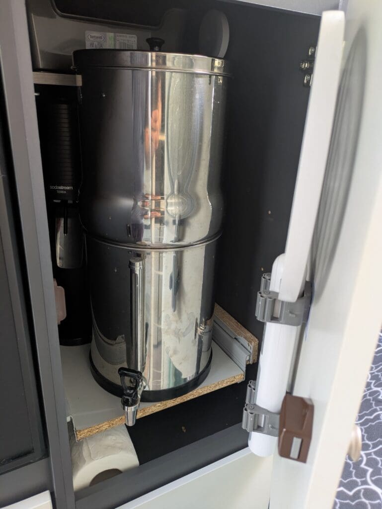 Filtre à eau Weeplow et machine Sodastream rangés dans un placard de fourgon aménagé