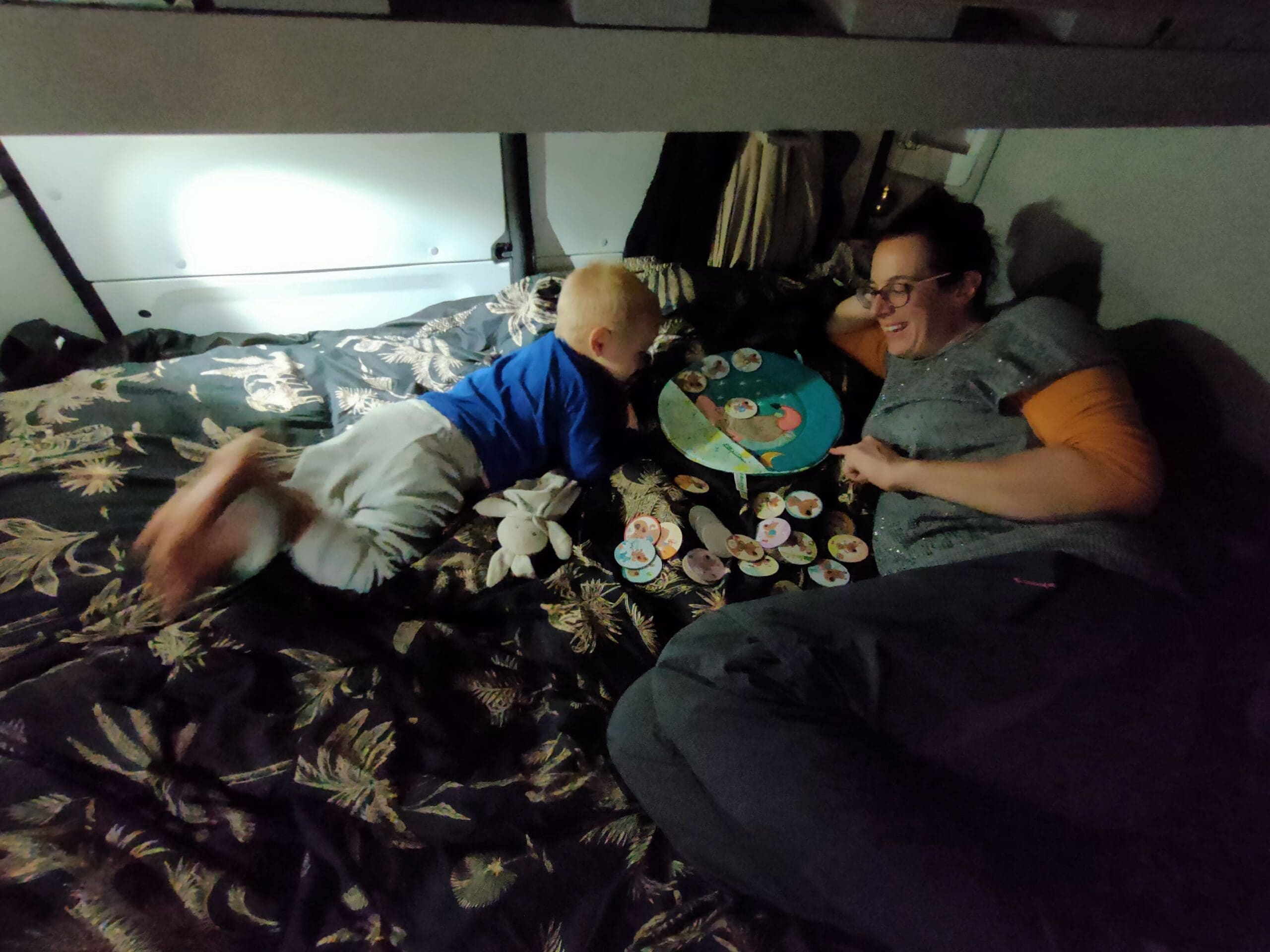 Lili et Tom dans le lit du van qui préparent le planning de la journée — organisation vanlife famille SED Aventures