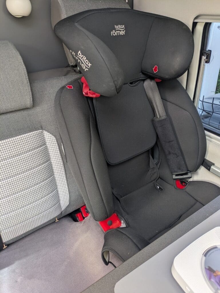 Siège auto Britax Römer fixé en isofix dans un van aménagé — sécurité enfant vanlife
