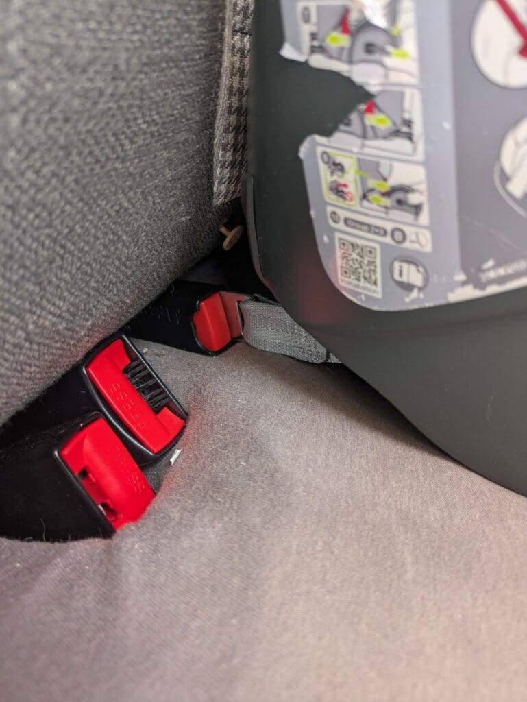 Connecteurs isofix rouges d'un siège auto Britax Römer fixés sur le rail du van — norme sécurité enfant